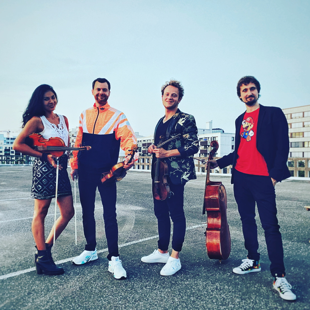 Feuerbach Quartett - stehend auf einem Parkplatz mit Instrumenten